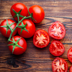 some-tomatoes-slices-with-knife-wooden-cutting-board-top-view